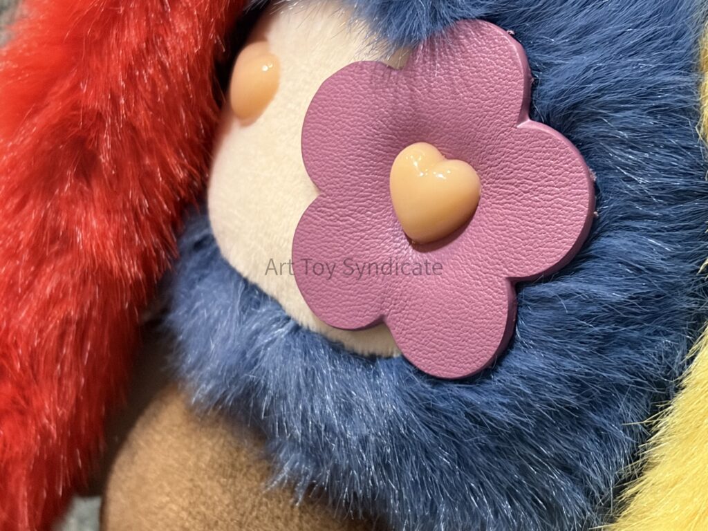 juju Mismatched「Cleo」の顔アップ。紫色の花とオレンジのハート型の芯パーツ。